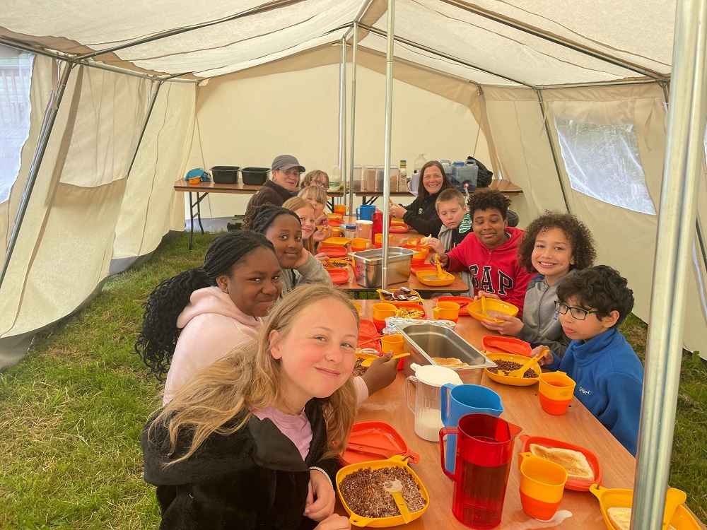 Kids enjoying an outdoor meal at Lineham Farm on a camping trip