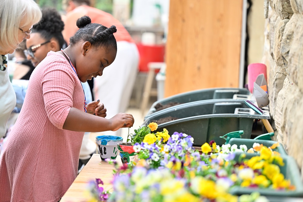 Young girl planting flowers at Leeds Children's Charity