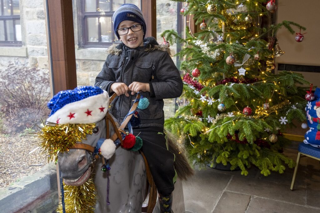 Child enjoying themselves on rocking horse at Lineham Farm at Christmas